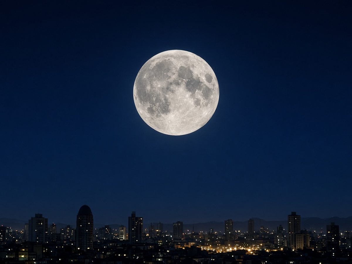 Lua cheia brilhante no alto do céu noturno sobre a silhueta de prédios de uma cidade