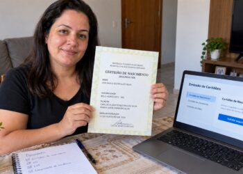 Mulher mostra segunda via da certidão de nascimento.